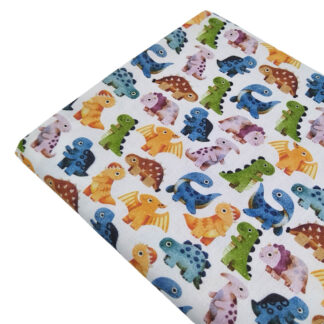 Tela de popelín con estampado de dinosaurios bebés de colores