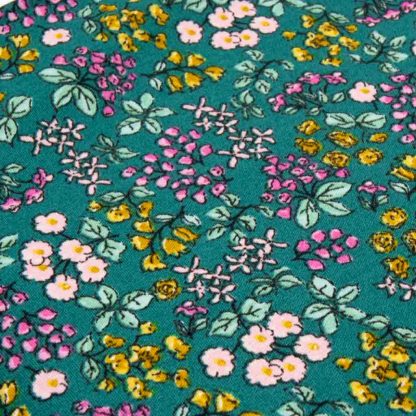 Tela popelín 100% algodón con estampado de ramilletes de flores de colores sobre fondo color verde diseñado by Poppy Europe