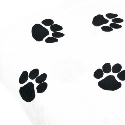 Tela de loneta de algodón estampada con huellas de perro negras sobre fondo color blanco. Dog Paw Designed for you by POPPY Europe