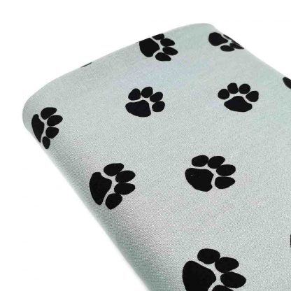 Tela de loneta de algodón estampada con huellas de perro negras sobre fondo color jade. Dog Paw Designed for you by POPPY Europe