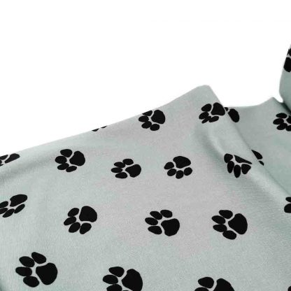Tela de loneta de algodón estampada con huellas de perro negras sobre fondo color jade. Dog Paw Designed for you by POPPY Europe
