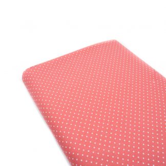 Tela de popelín 100% algodón con estampado de topos blancos pequeños sobre fondo color rosa coral diseñado by Poppy Europe