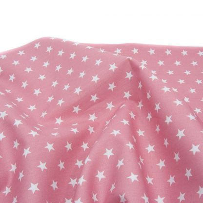 Tela de popelín 100% algodón con estampado de estrellas blancas pequeñas sobre fondo color rosa palo diseñado by Poppy Europe