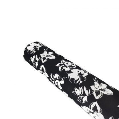 Tela elástica de satén de algodón con estampado de flores blancas sobre fondo negro