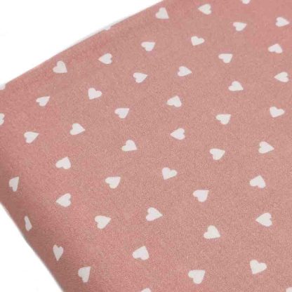 Tela de popelín de algodón orgánico estampado con corazones sobre fondo rosa palo
