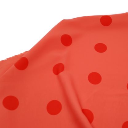 Tela para trajes de flamenca en crep elástico con lunares de 30 milímetros color naranja sobre fondo color coral