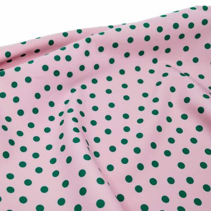 Tela bielástica especial para coser trajes de flamenca con estampado de lunares de 8 milímetros en color verde botella sobre fondo color rosa empolvado