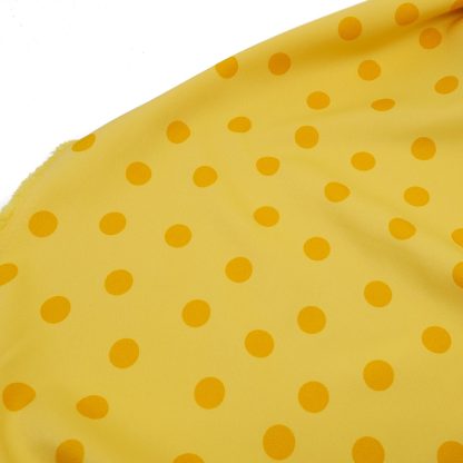 Tela bielástica especial para coser trajes de flamenca con estampado de lunares de 15 milímetros en color mostaza sobre fondo color amarillo