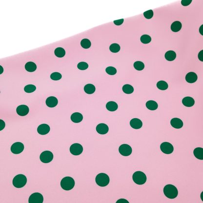 Tela bielástica especial para coser trajes de flamenca con estampado de lunares de 15 milímetros en color verde botella sobre fondo color rosa empolvado