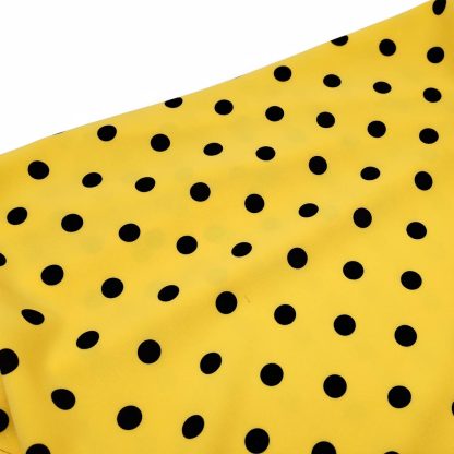 Tela especial para coser trajes de flamenca en crep elástico con estampado de lunares negros de 10 milímetros sobre fondo color amarillo
