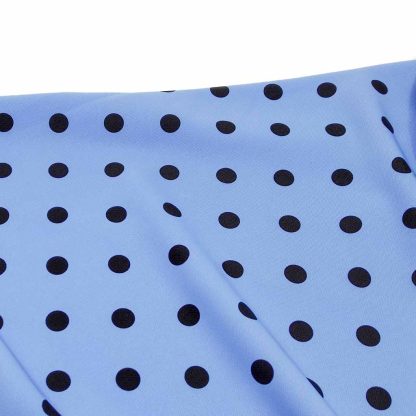 Tela especial para coser trajes de flamenca en crep elástico con estampado de lunares negros de 10 milímetros sobre fondo color azulado