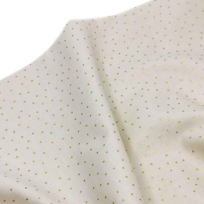 Tela batista de algodón orgánico tipo voile estampada con mini topos color dorado sobre fondo color lino