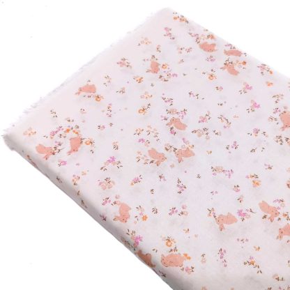 Tela batista de algodón orgánico estampada con conejitos y flores en tono rosa empolvado