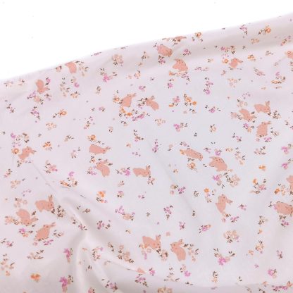 Tela batista de algodón orgánico estampada con conejitos y flores en tono rosa empolvado