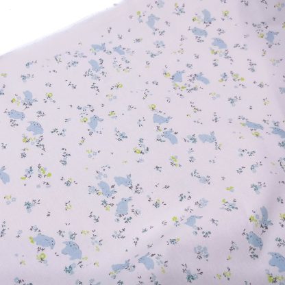 Tela de batista en algodón orgánico con estampado de conejitos y flores en tonos azul empolvado