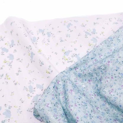 Telas de batista en algodón orgánico con estampados de conejitos y flores en tonos azul empolvado